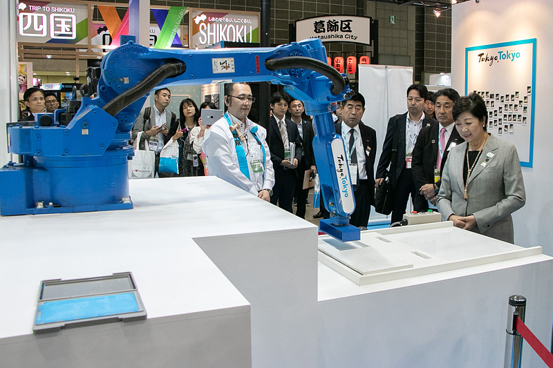 小池都知事がスタートボタンを押すとロボットアームが動き、「Tokyo Tokyo」のスタンプを押印した