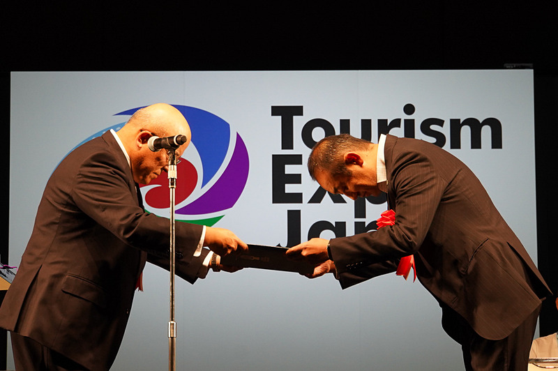 プレゼンターのJATA 会長 田川博己氏より賞状などの贈呈が行なわれた