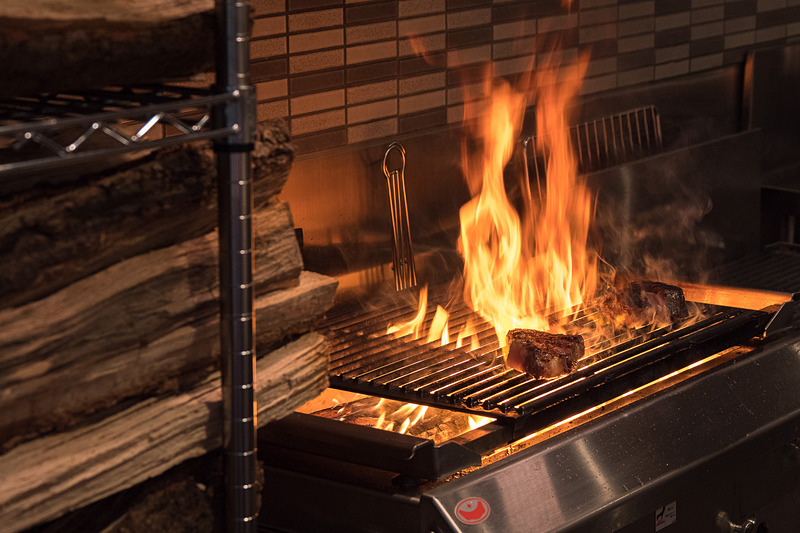 キッチンで豪快に薪焼きされるステーキ