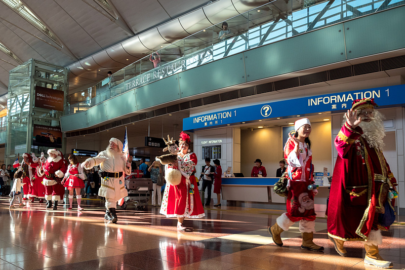 「オーホッホッホッ！」の声を響かせながら羽田空港の出発ロビーを行進するサンタクロース