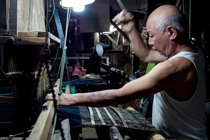 職人が手動の機織り機で反物を作る