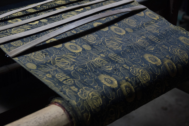 職人が手動の機織り機で反物を作る