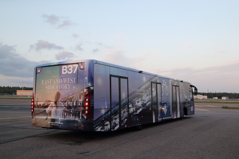 上映会場となるフィンエアーの格納庫まで、これから飛び立つフィンエアーのA350XWBを横目で見ながらバスで移動します。バスの1台は「East and West Side Story」のラッピングバス。ヘルシンキ市内と空港を結ぶシャトルバスにもラッピングしたタイプを見かけました