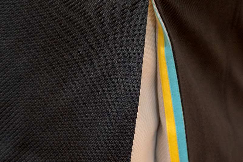 スカートのボックスプリーツにAIR DOのコーポレートカラーのテープをあしらっている