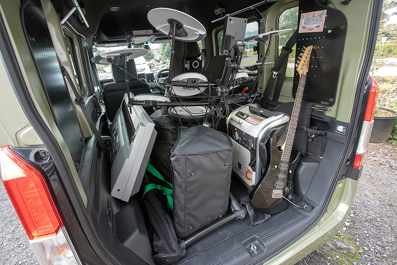 このあとさらにドラムなど走行中に動いてほしくないモノには純正アクセサリのルーフインナーサイドパイプにタイダウンベルトを引っかけて上からも固定。ギターのネック部のところにあるのは純正アクセサリの有孔ボード。市販フックやマグネットが付くのでロックな写真やイラストを飾って雰囲気を盛り上げることもOK！