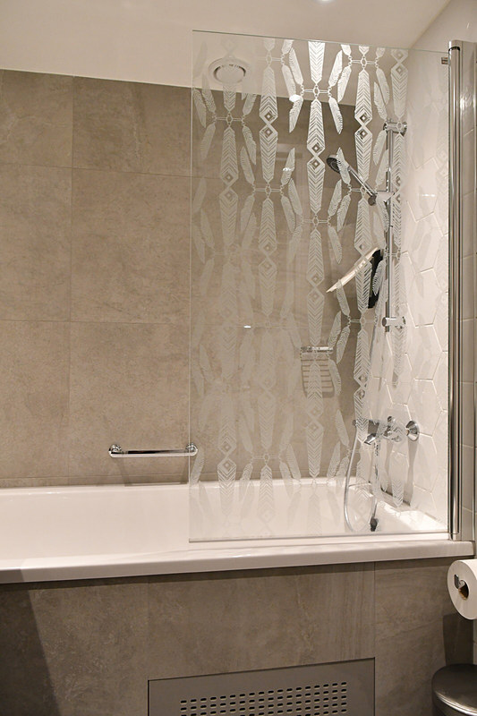 バスルーム。大きめの湯船には可動式のガラス仕切りがある