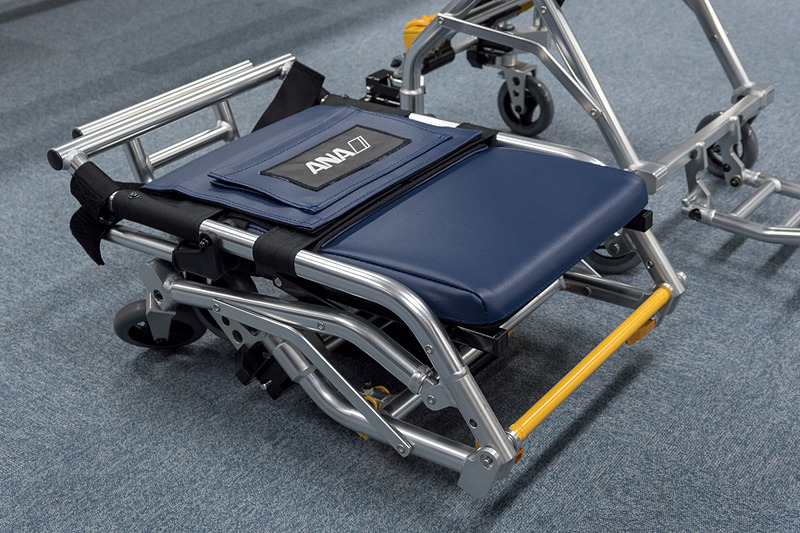 機内用車いすは折りたたんだ状態で飛行機内に配備されている。手すりの上げ下げが可能で、背もたれにはサポートベルトを装備。4WS（四輪操舵）なので機内でも小回りが効く
