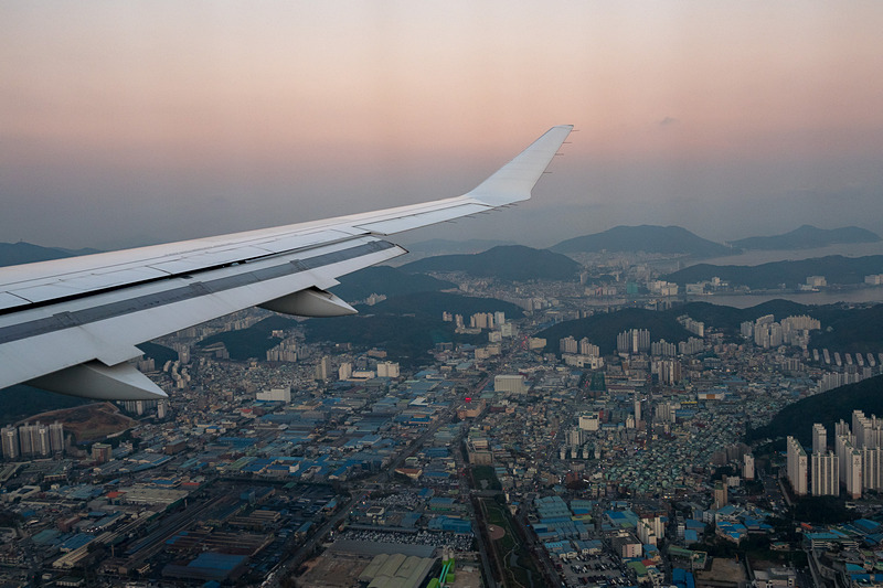 夕焼けに包まれる釜山の街並みを眺めながら着陸