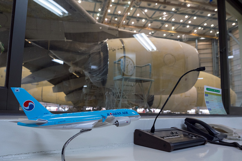 作業や搬出入の指示を行なうハンガー・コントール・センターから見学。下塗りのプライマーが剥き出しになったエアバス A380型機の作業が行なわれていた。写真右下は、水平尾翼付け根部分の塗装の変更点