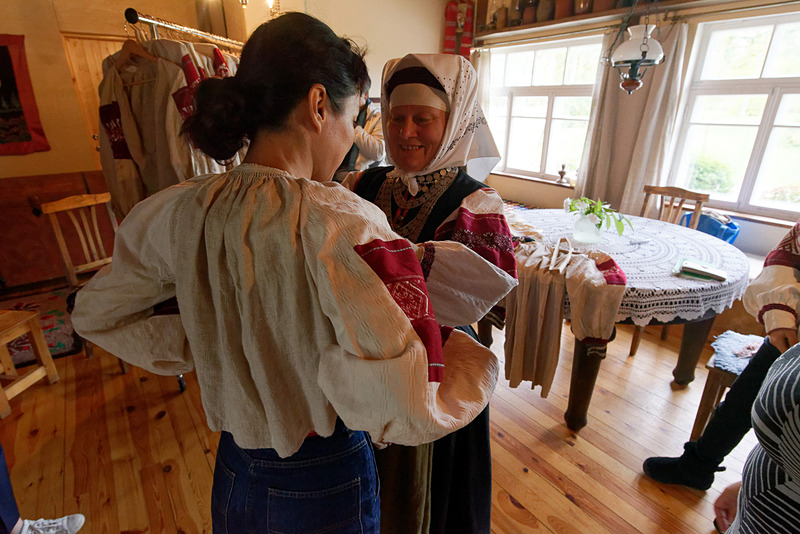 手伝ってもらいながら上着、エプロンなどを1枚ずつ着ていく