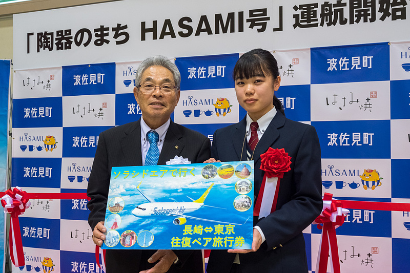 波佐見町長 一瀬氏から、機体デザインを考案した波佐見高校 美術・工芸科の中尾百花さんへ目録を贈呈