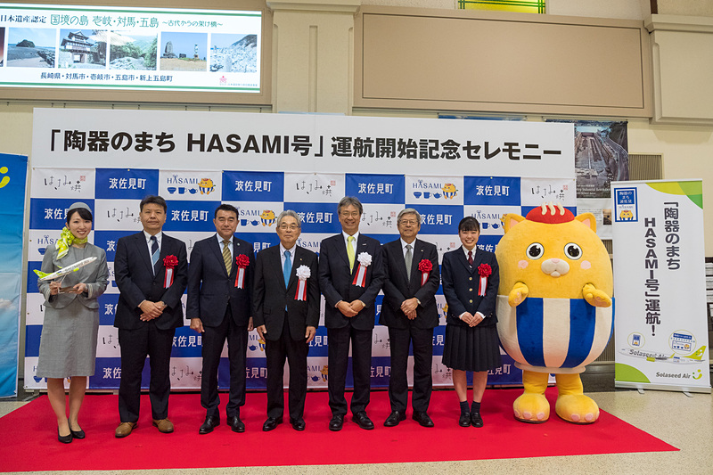 左からソラシドエアCA、国土交通省 大阪航空局 長崎空港事務所 空港長 小川順平氏代理・総務課長 徳永行彦氏、波佐見町観光協会 会長 松下和徳氏、波佐見町 町長 一瀬政太氏、株式会社ソラシドエア 代表取締役社長 髙橋宏輔氏、長崎空港ビルディング株式会社 代表取締役社長 中村昭彦氏、波佐見高校 美術・工芸科 中尾百花さん、波佐見町公式マスコットキャラクター はちゃまる