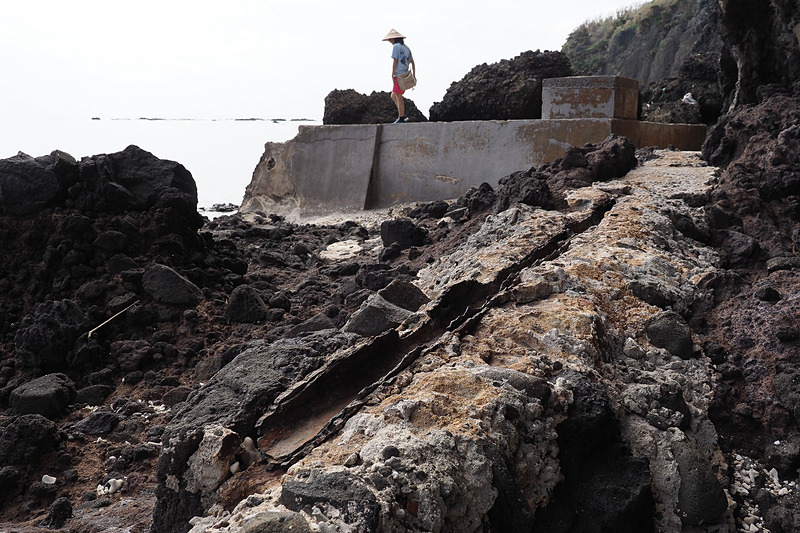 女性が乗っているのがかつての貯水タンク。手前に錆びついた水道施設も見えます