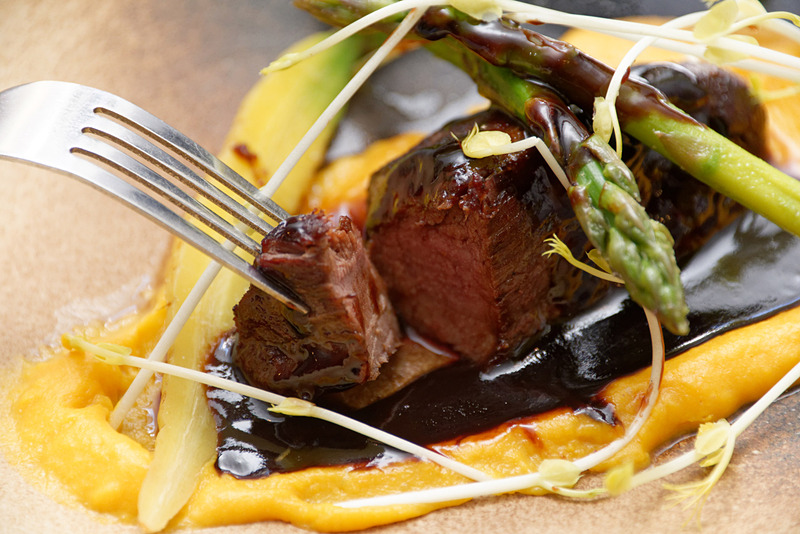 野生イノシシのステーキ。ポテトとニンジンのチェダーソースに、アスパラなどが添えられている