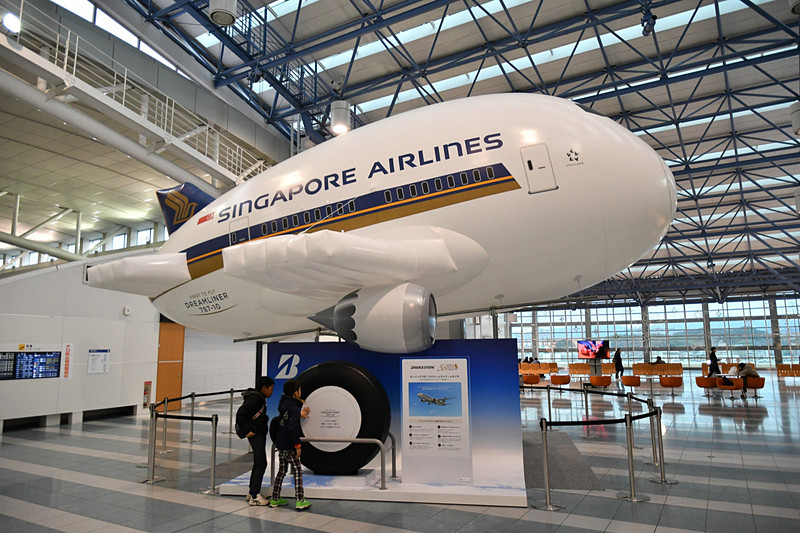 福岡空港国際線ターミナルの4階に展示されている「787-10型機」の巨大バルーンとブリヂストン製タイヤ