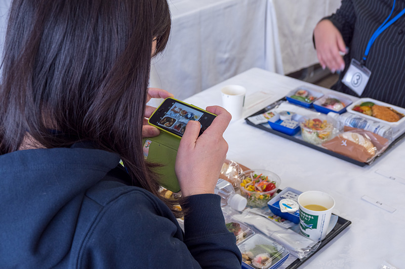 CA（客室乗務員）とシェフによる、機内さながらのカートを用いた配膳ののち試食。参加者同士で異なるメニューの写真を撮り合ったり、シェフと話しをしたり、それぞれの時間を楽しんでいる様子だった