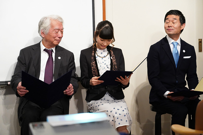 フィンランド産の白樺に特別にプリントされたという任命状を見入る親善大使の皆さん