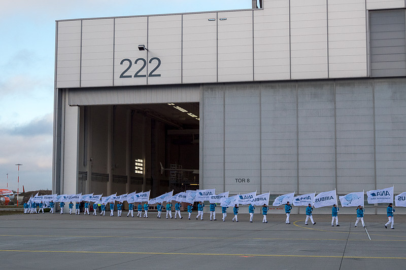 ハンガーのドアが開き始めるとともに、エアバスとANAの旗を持ったチームが登場