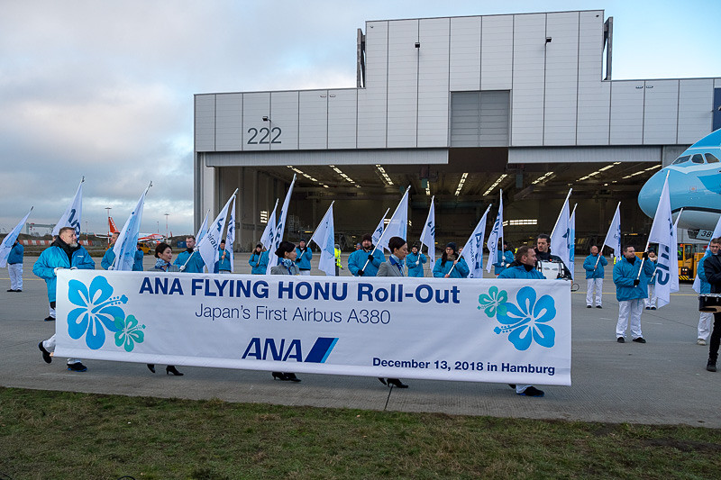 FLYING HONUが前進して定位置に向かうのと同時に、ANAのCAとエアバススタッフが横断幕を持って登場。記念撮影へ