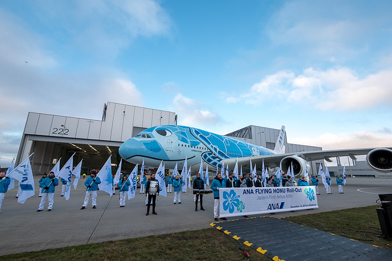 FLYING HONUが前進して定位置に向かうのと同時に、ANAのCAとエアバススタッフが横断幕を持って登場。記念撮影へ