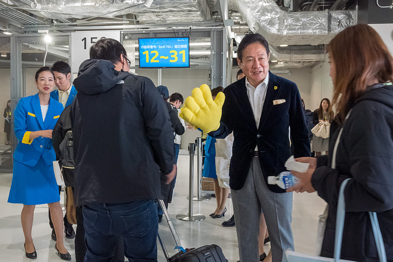 搭乗口で記念品配布のほか、ハイタッチや旗振りで乗客を歓迎
