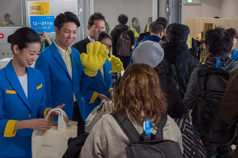 搭乗口で記念品配布のほか、ハイタッチや旗振りで乗客を歓迎