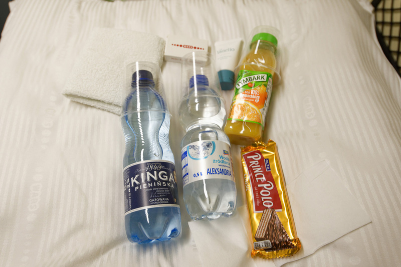 水、炭酸水、オレンジジュース、スナック、タオルや洗顔フォームなどが用意されている