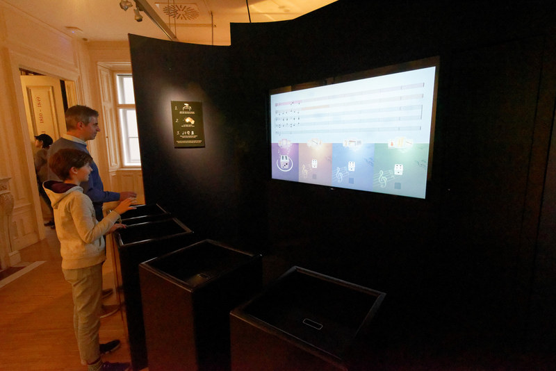 同時に複数人で遊べる自動作曲のアトラクション。手前のセンサーの上に手をかざしたり、握ったりすると、画面上のサイコロを持ち上げて振ることができる。出目によって楽器パートごとのメロディが生成され、最後に合奏を聞ける