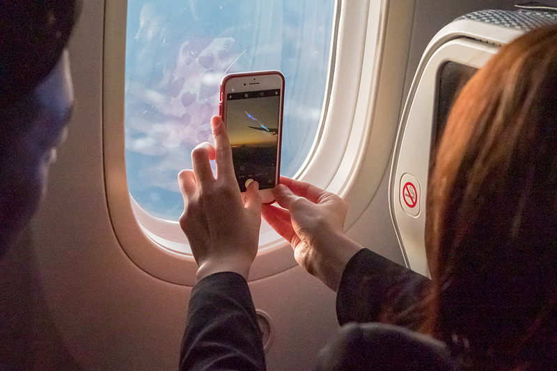 デジカメやスマホでの撮影を楽しむ乗客。右側、左側の両方の窓から望めるよう長野県駒ヶ根市付近上空で小さく旋回