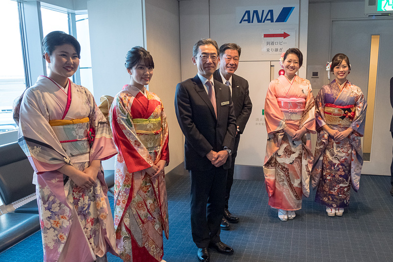 平子社長と、南日隆男 東京空港支店長、振り袖姿の地上旅客スタッフが乗客をお見送り