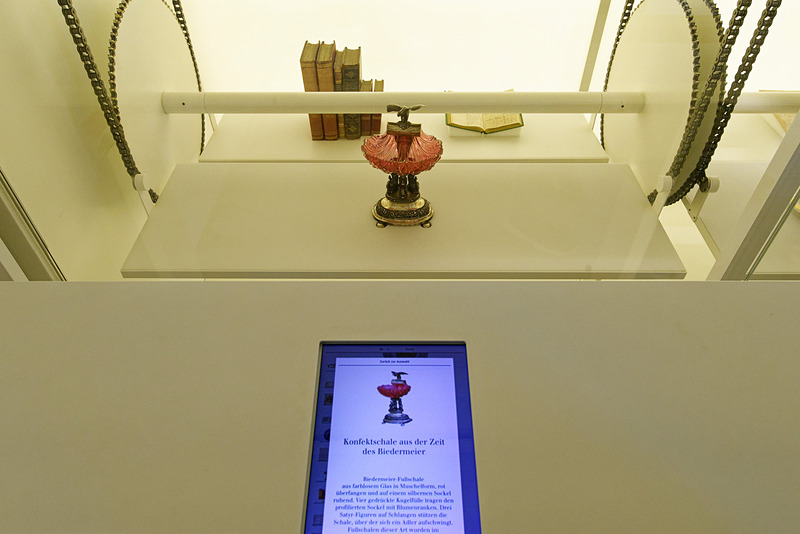 調度品が昇降台でゆっくり動いている。手前にあるタブレットで品々の詳細が分かる