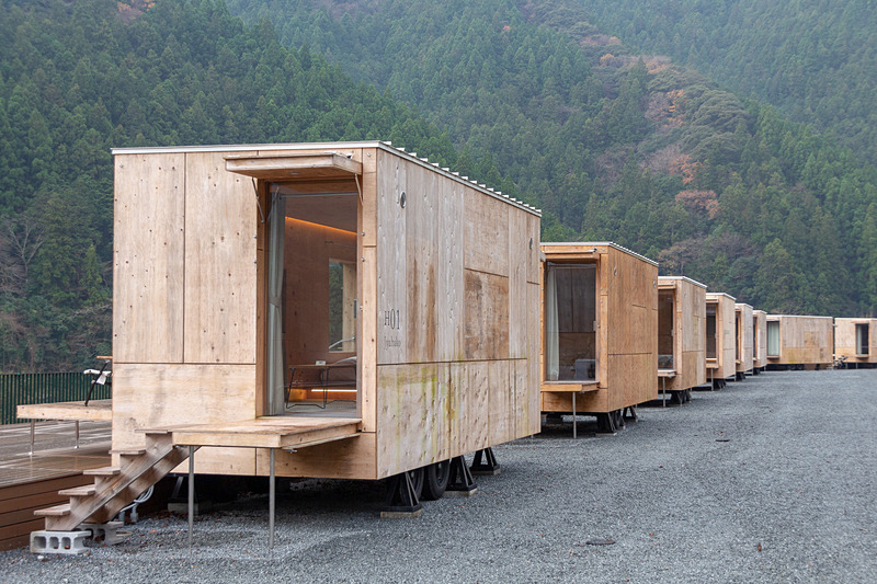 木材の質感たっぷりなトレーラーハウス「住箱-JYUBAKO-」。ウッドデッキ沿いに10棟がズラリと並ぶ