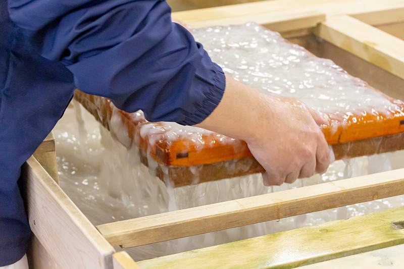 原料の入った水溶液をよくかき混ぜ、簀桁ですくい上げる。紙の厚さを均等にするために前後左右に振り、水を切って枠を外す。あとは台の上で乾燥させれば出来上がり。水は冷たいし重いしで、結構大変な作業