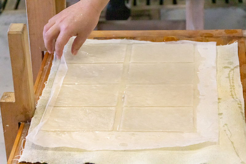 原料の入った水溶液をよくかき混ぜ、簀桁ですくい上げる。紙の厚さを均等にするために前後左右に振り、水を切って枠を外す。あとは台の上で乾燥させれば出来上がり。水は冷たいし重いしで、結構大変な作業