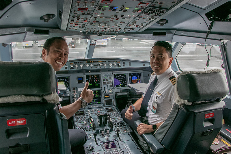 GA875便のパイロットやCA（客室乗務員）はとてもフレンドリーで親切。乗客たちが手を振ると、パイロットも手を振り返してくれた。CAの制服は民族衣装「サロンケバヤ」をモチーフにしたデザイン。一般の女性CAは「ピーコックブルー」と「オレンジ」の2種、女性パーサーは「ブルー」、ファーストクラス担当は「パープル」の制服を着用している