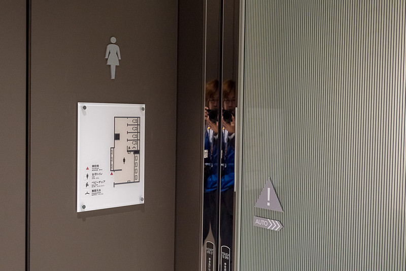 化粧室。通路向かって左奥に多機能トイレと女性用化粧室、右奥に男性用