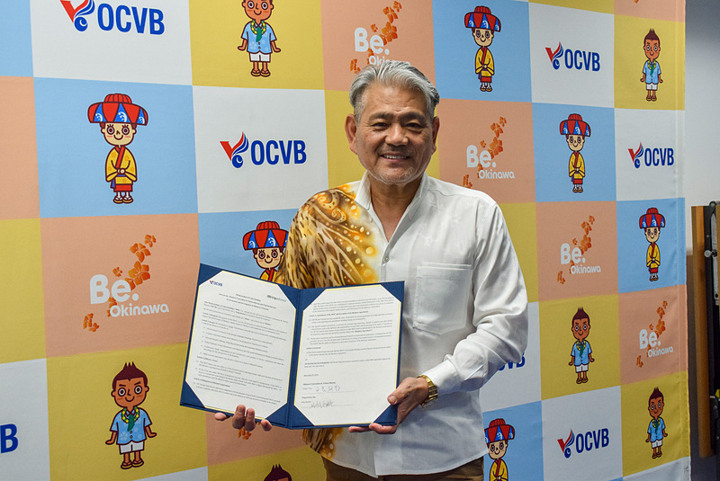 トリップアドバイザーとの締結書を紹介する平良会長