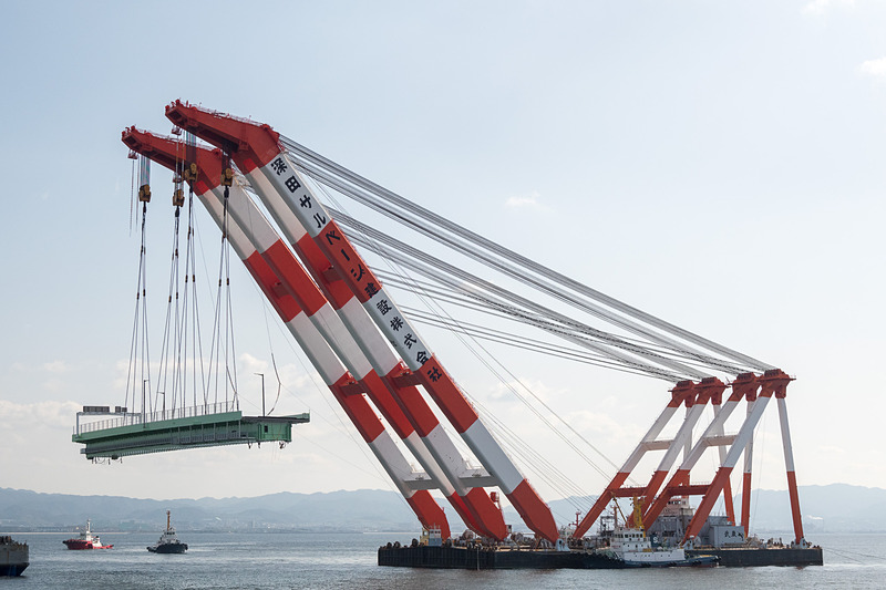 NEXCO西日本がタンカー衝突で損傷した関空連絡橋の架設作業を開始。昼間にFC（フローティングクレーン）船を使った橋桁の吊り上げ作業が行なわれた