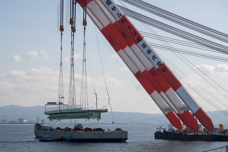 その後、本格的に吊り上げを開始。高さ約15mまで吊り上げ、そのまま武蔵がやや後退した位置で停止。夜までここで待機する。台船は昼間のうちにこの場を離れる