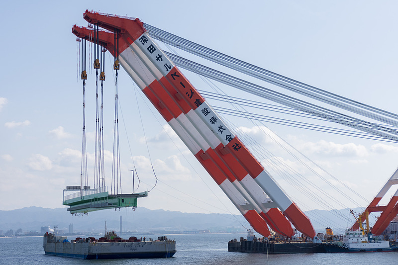 その後、本格的に吊り上げを開始。高さ約15mまで吊り上げ、そのまま武蔵がやや後退した位置で停止。夜までここで待機する。台船は昼間のうちにこの場を離れる