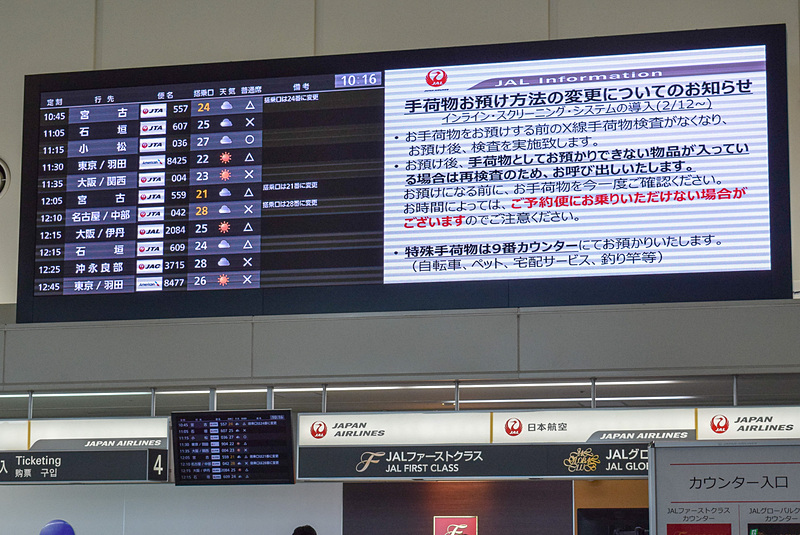 JALグループカウンター正面掲示板には、荷物預け時の手順変更の案内が表示された