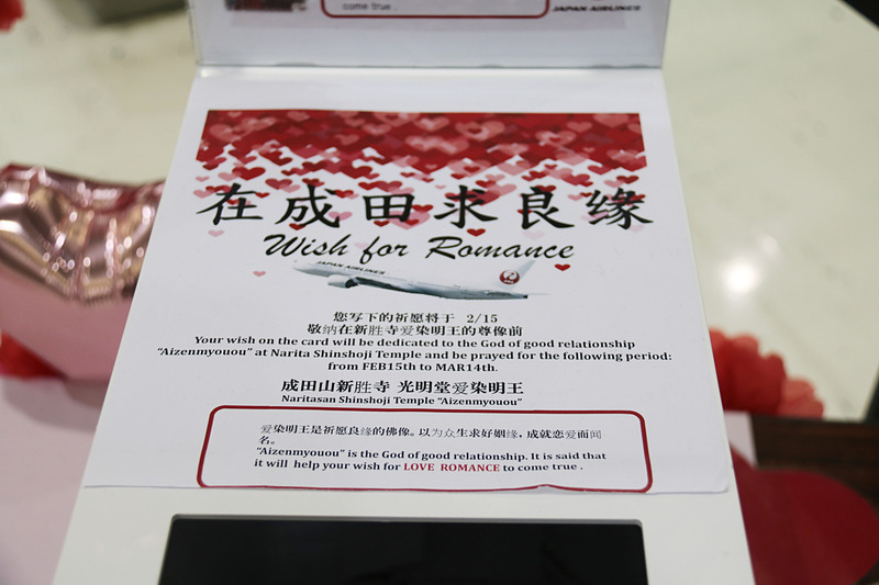 「成田で縁結び」に関する説明パネルと、記入済みカードボックスに貼られていた英語と中国語の説明文。2月15日から3月14日まで宝前に奉納される