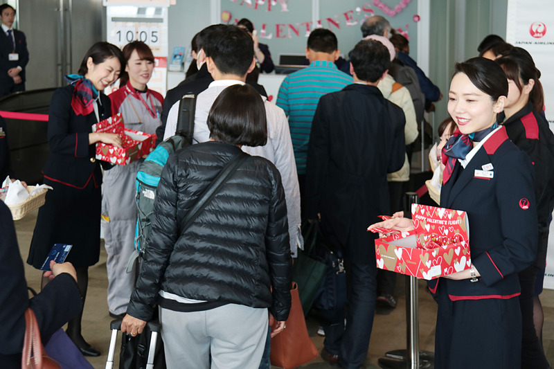 チョコレートを配布するJALグループのスタッフたち。R搭乗ゲートでのイベントでは男女10人のスタッフが参加していた
