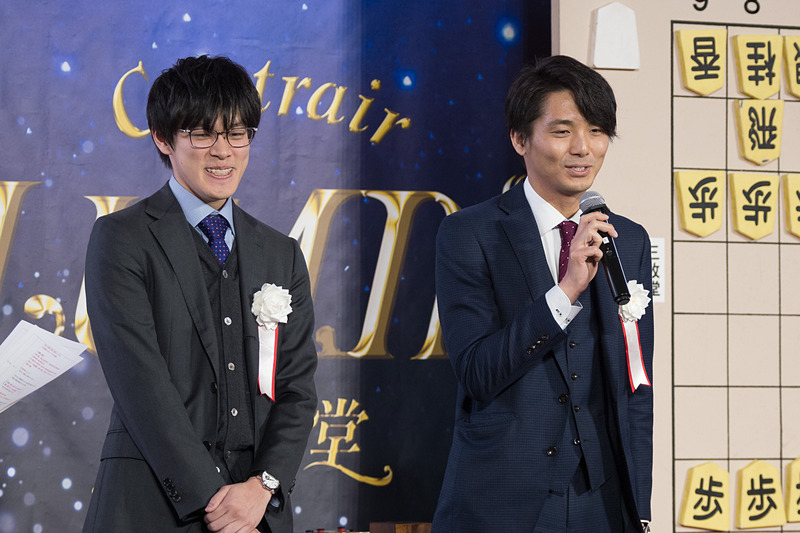 公開対局は午前、午後に1回ずつ行なわれ、午前中は「プロのすごさを分かっていただける」（都成五段）と語る目隠し対局で、三枚堂達也六段と都成竜馬五段が対戦。解説を杉本昌隆七段、聞き手を中澤沙耶女流初段が務めた