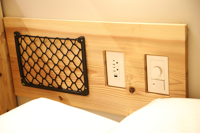 シンプルなベッドスペースはアメニティもシンプル。ベッドサイドには鉄道を感じさせる小物入れも