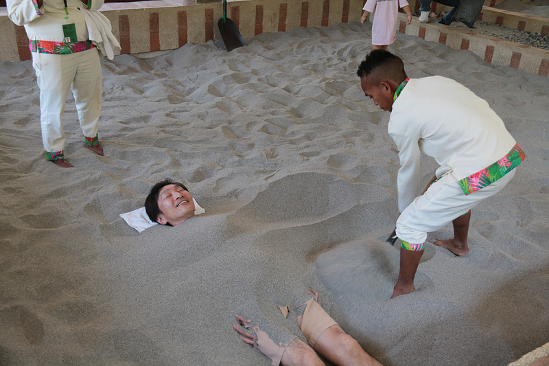 砂風呂で半生き埋めにされる筆者。決して熱いわけではないが10分を過ぎたころから、じわりと汗が湧き出てくる。約20分で終了し立ち上がると、発汗がとても爽やかに感じた