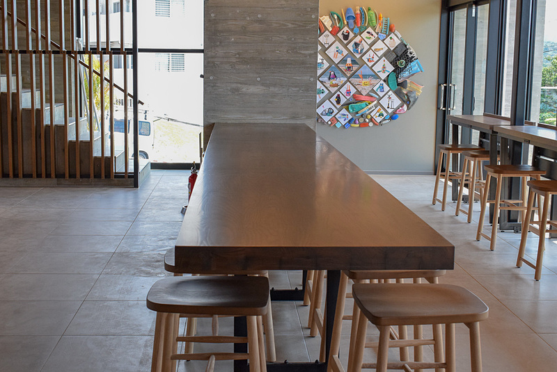 中央にある琉球松製のメインテーブルは5メートルほどの長さがある。シックで落ち着いた色調がコーヒーに合っている