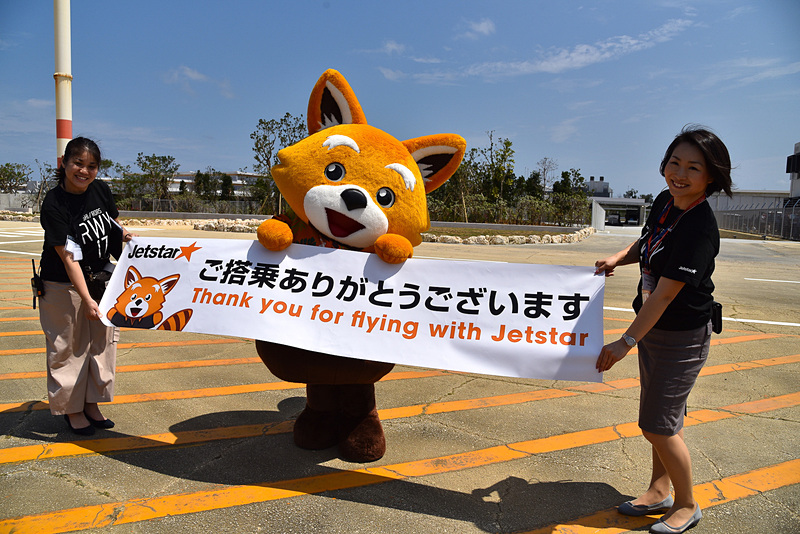 ジェッ太とスタッフらが「ご搭乗ありがとうございます」のメッセージが入った横断幕が掲げてお見送り