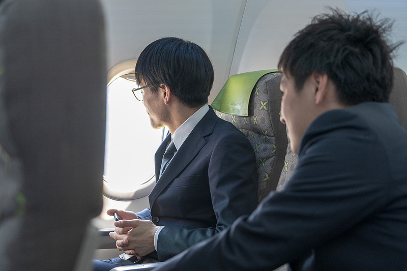 それぞれの思いを胸に窓の外を見る新入社員の皆さん。入社式直後に飛べるなんて最高の思い出ですね
