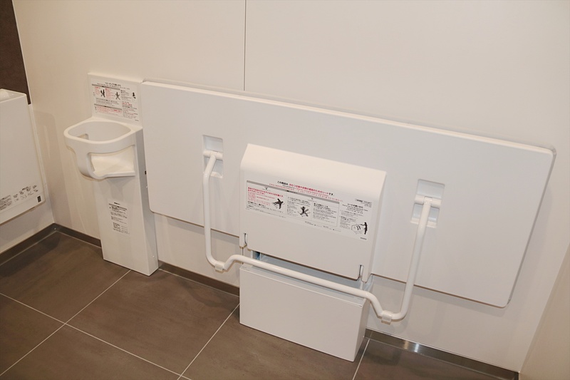 こちらがexperience TOTOの多機能トイレの内部。便座の右奥壁面に埋め込まれているのがスピーカー兼マイクユニット。ドア上部には開閉センサー、天井には人感センサー